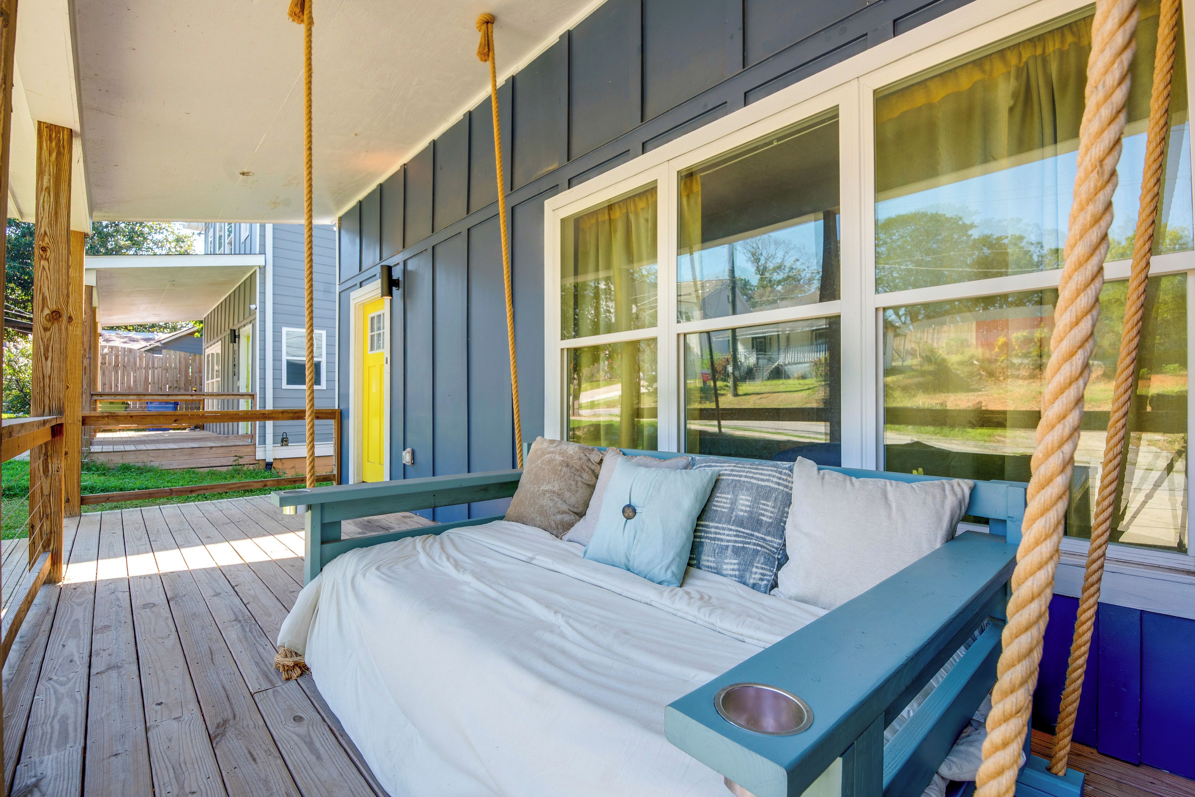 A bedroom with a bed, pillows, a bench, and a window.