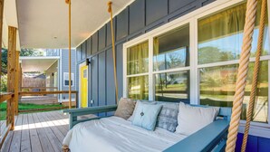 Un dormitorio con una cama, almohadas, un banco y una ventana.