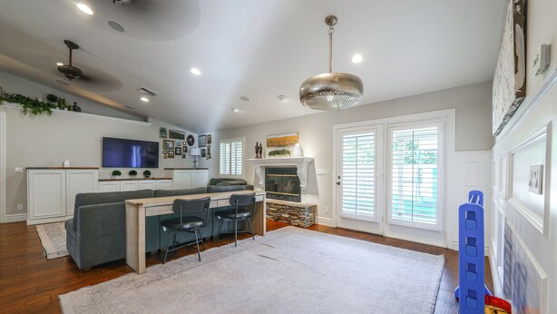 A modern kitchen with white cabinets, a built-in oven, and a large window.