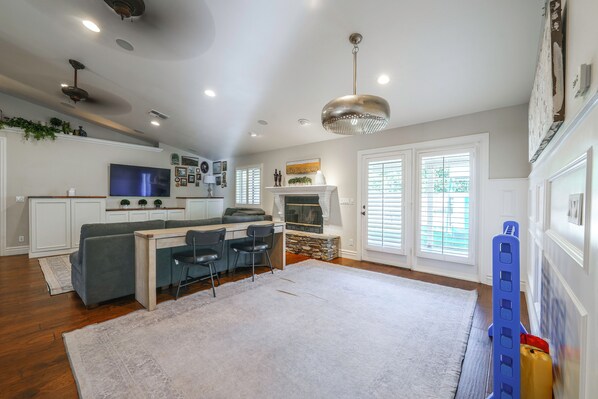 A modern kitchen with white cabinets, a built-in oven, and a large window.