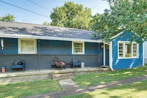 A two-story house with a porch, a small attached garage, and a front yard with a lawn and a tree. - 5 Mi to Honky Tonk Hwy! Charming Escape w/ Porch (Nashville)