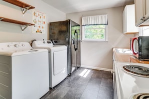 A compact kitchen with a washing machine, a refrigerator, a stove, and a window with curtains. - 5 Mi to Honky Tonk Hwy! Charming Escape w/ Porch (Nashville)