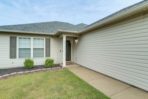 A residential house with a front porch, a small garden, and a garage.