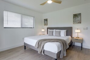 A bedroom with a bed, bedside lamps, a ceiling fan, and artwork on the walls. - Waterfront Hollywood Oasis w/ Private Pool! (Hollywood)