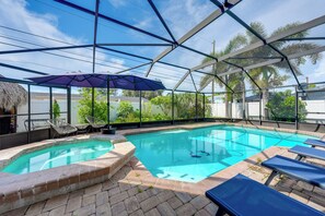An indoor swimming pool with a glass enclosure, surrounded by lounge chairs and a thatched roof structure. - 2 Mi to Redington Beach! Tropical Poolside Retreat (Seminole)