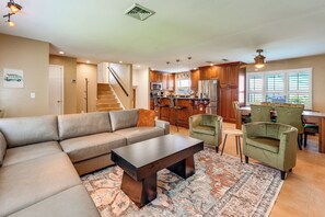 A spacious living room with a large sectional sofa, a coffee table, and a patterned rug. - 2 Mi to Redington Beach! Tropical Poolside Retreat (Seminole)