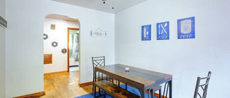 Un espace repas comprenant une table et des chaises, un ventilateur de plafond et des œuvres d’art murales.