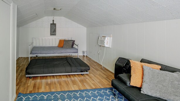 Ein kleines Zimmer mit zwei Betten, einer Schlafcouch, einer Heizung und einer Wand-Klimaanlage.