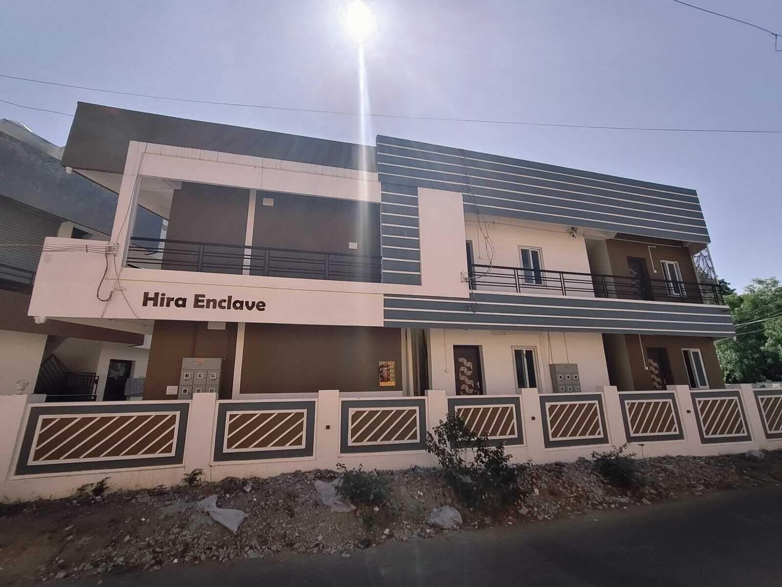 A two-story building with a sign reading 'Hira Enclave.'