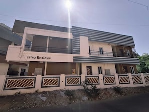 Un immeuble de deux étages sur lequel on peut lire l’inscription « Hira Enclave ».