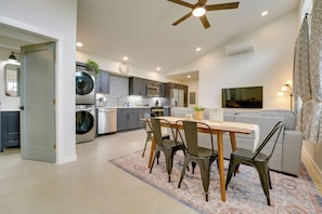 A modern kitchen with a dining area, a ceiling fan, and a living room with a sofa and a TV. - Modern Unit Near the Best of Grand Junction (Grand Junction)