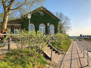 A building with a green ivy-covered exterior, a brick facade, and arched windows. - Holiday Apartment With 2 Bedrooms (Varel)
