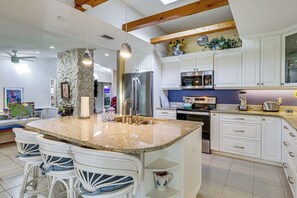 A spacious kitchen with a large island, white cabinetry, and modern appliances. - Families w/ Pups! Home Near Florida Beaches (Palm Bay)