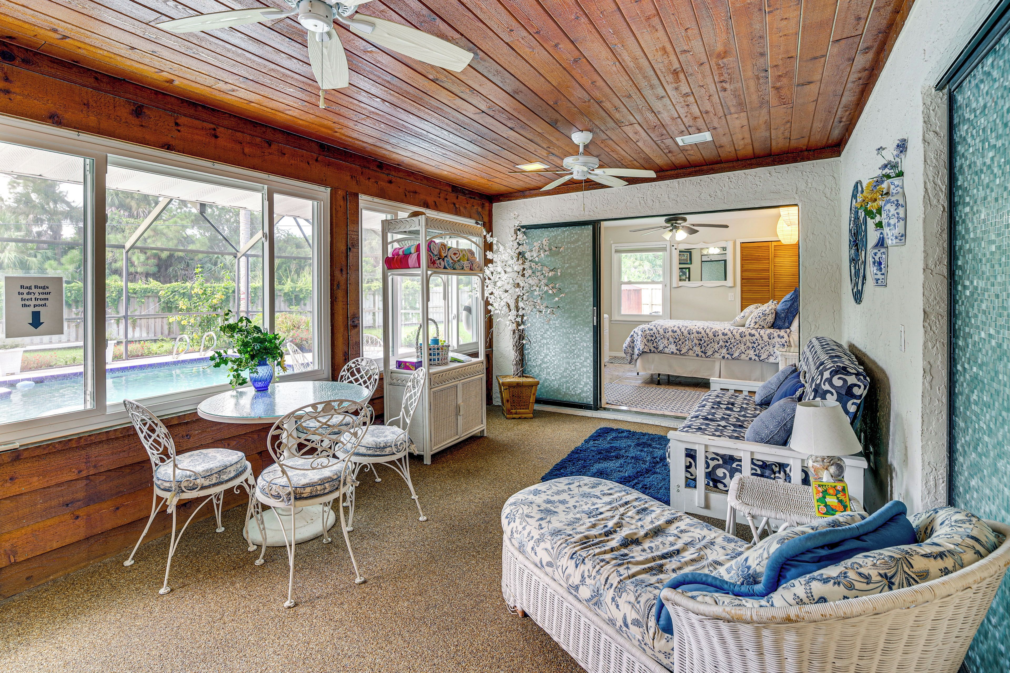 Una habitación acogedora con vista a la piscina, muebles de mimbre y ventiladores de techo.