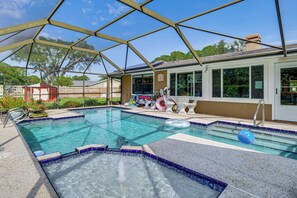 A swimming pool with a covered area, surrounded by a fence, and a house with a visible window and door. - Families w/ Pups! Home Near Florida Beaches (Palm Bay)