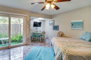 A bedroom with a bed, a desk, a chair, a television, and a balcony. - Families w/ Pups! Home Near Florida Beaches (Palm Bay)