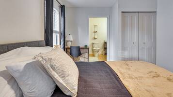 A bedroom with a bed, a bedside table, a lamp, and a wardrobe.