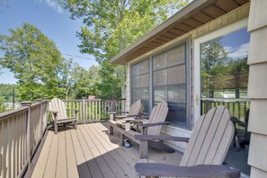 A wooden deck with Adirondack chairs and a table, overlooking a forested area. - Deck, Public Lake Access, Mountain Getaway (Equinunk)