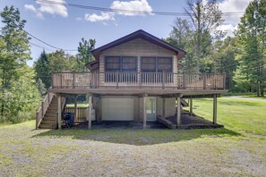 A two-story cabin with a balcony, a garage, and a covered porch area. - Deck, Public Lake Access, Mountain Getaway (Equinunk)