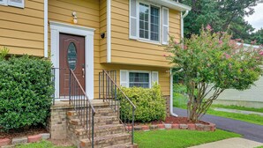 A two-story house with a front entrance, a small brick staircase, and a well-maintained lawn. - Charming Family Home 11 Mi to Dtwn Richmond! (Chesterfield)