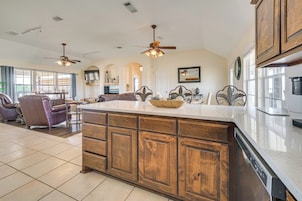 A spacious kitchen with a large island, wooden cabinets, and a dining area with a sofa and chairs.