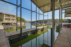 Marina com barcos atracados, área coberta com teto e um edifício com varanda.