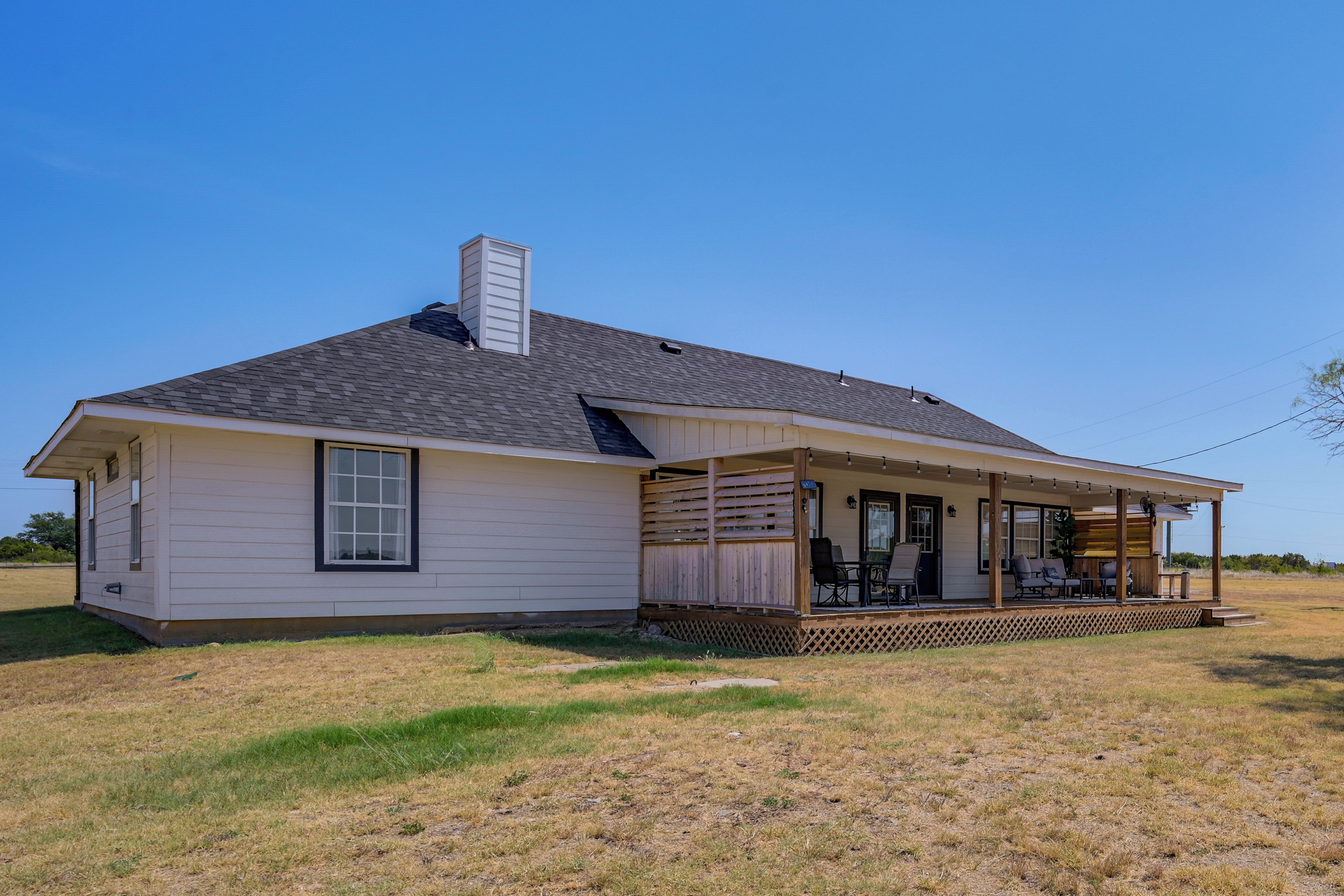 A single-story house with a covered porch and a chimney.