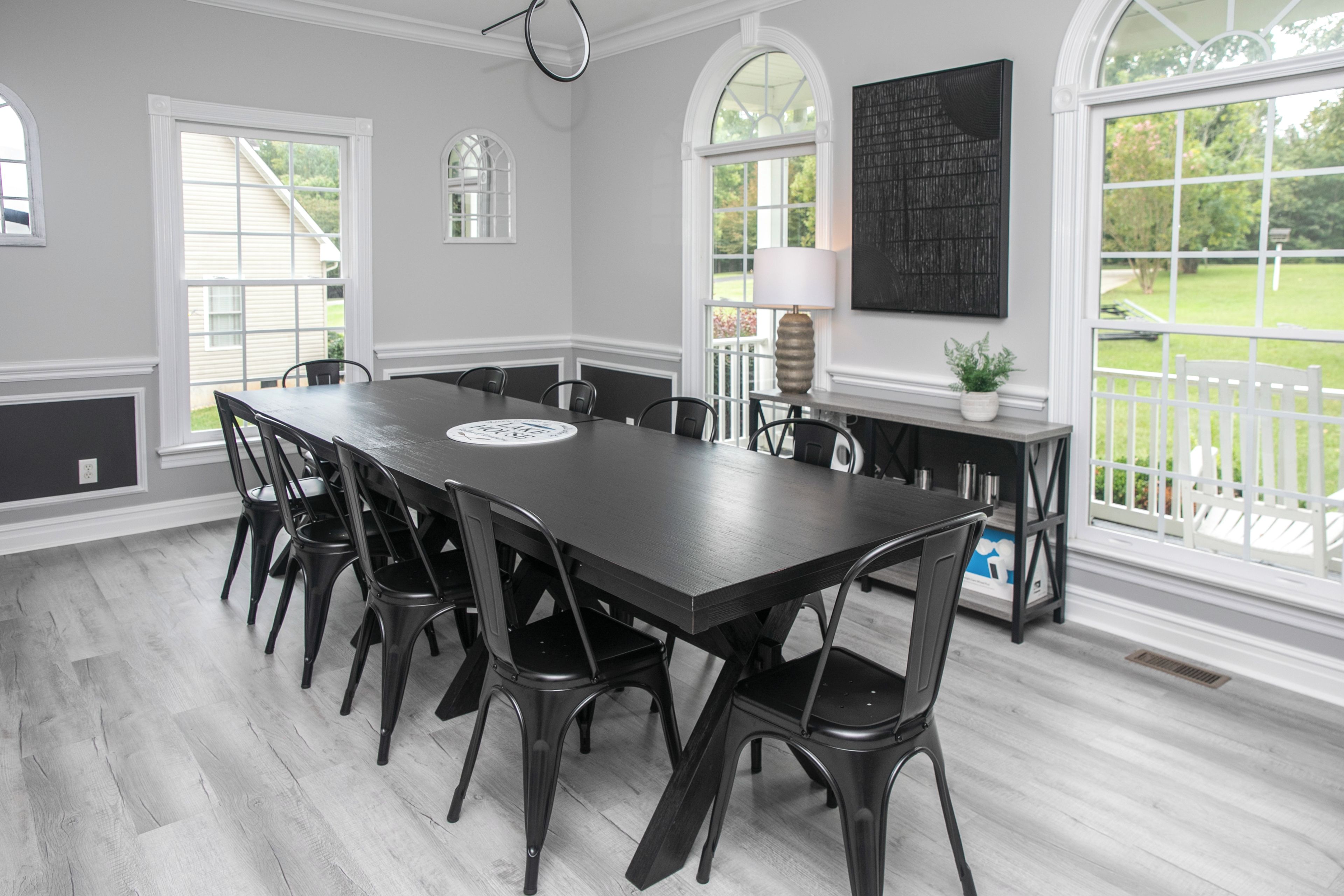 A dining area with a long table, chairs, and a view of the outdoors.