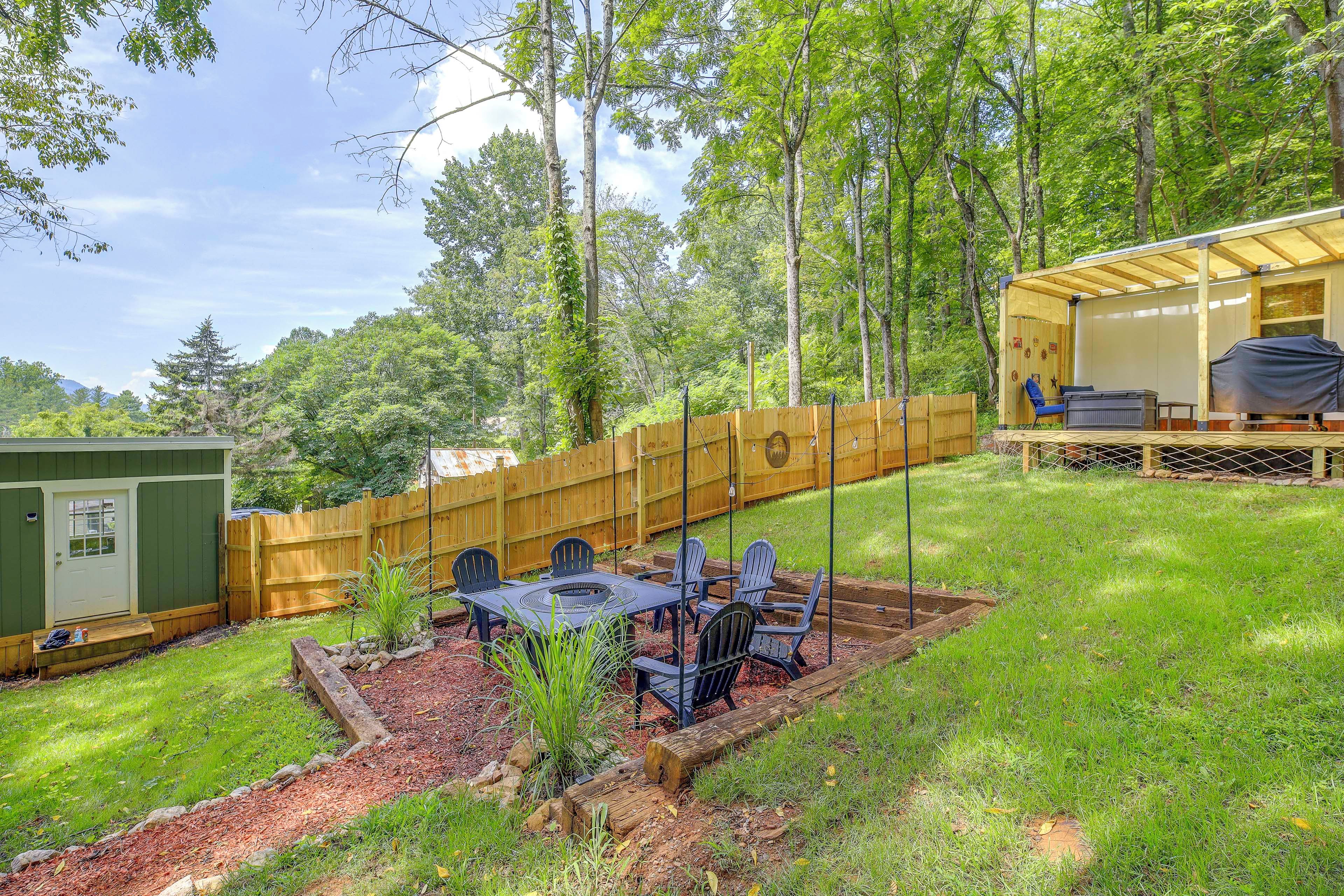 A backyard with a wooden deck, a covered seating area, and a barbecue grill.
