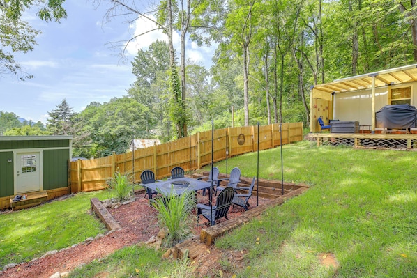 A backyard with a wooden deck, a covered seating area, and a barbecue grill.
