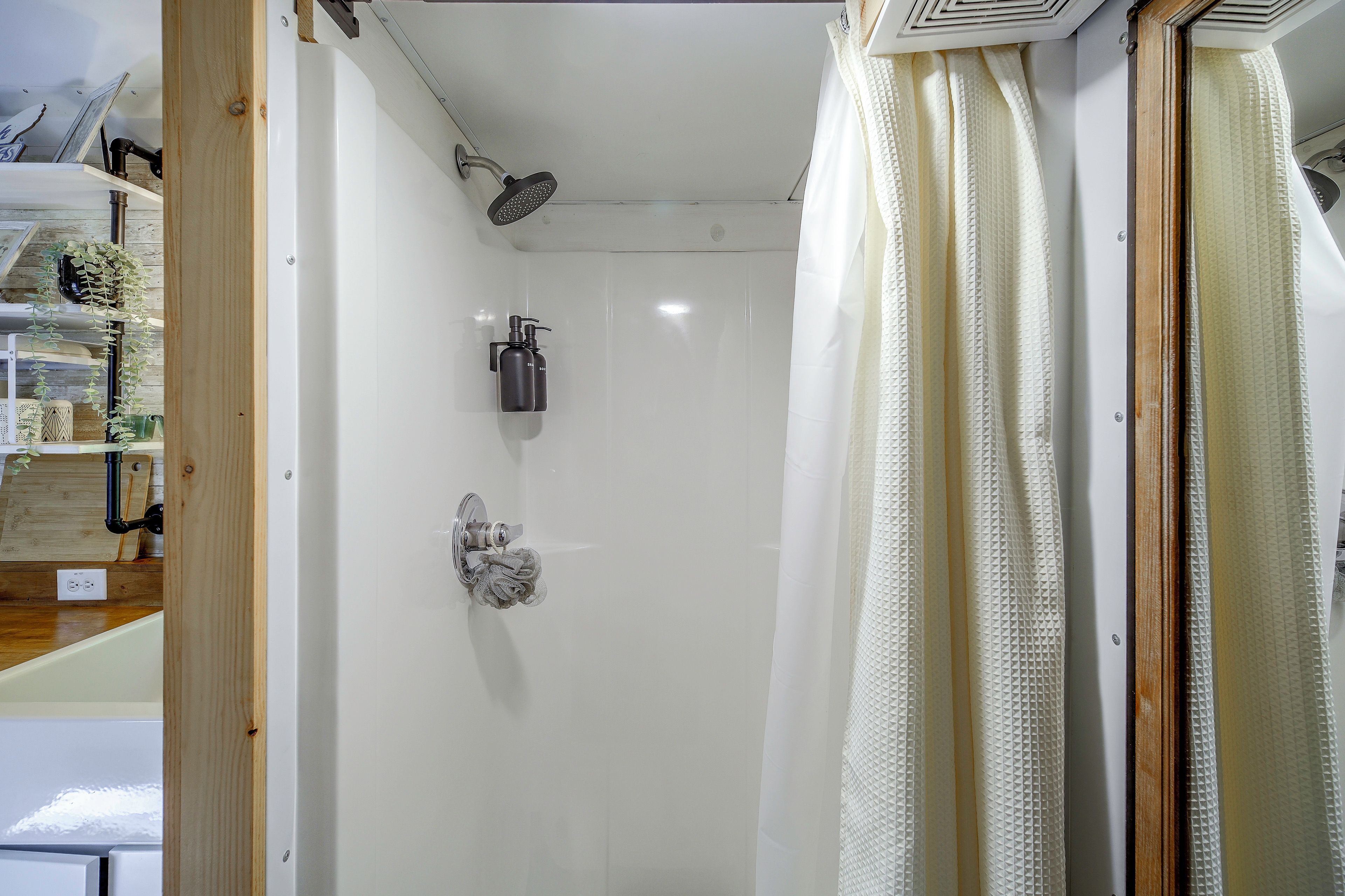 A bathroom with a shower, a towel rack, and a toilet.