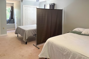 A bedroom with two beds, a window with curtains, and a door. - Fishing Dock & Sauna! Farmville Gem w/ Views (Farmville)