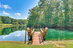 Une jetée en bois s’étendant sur un lac paisible, entouré d’une végétation luxuriante.