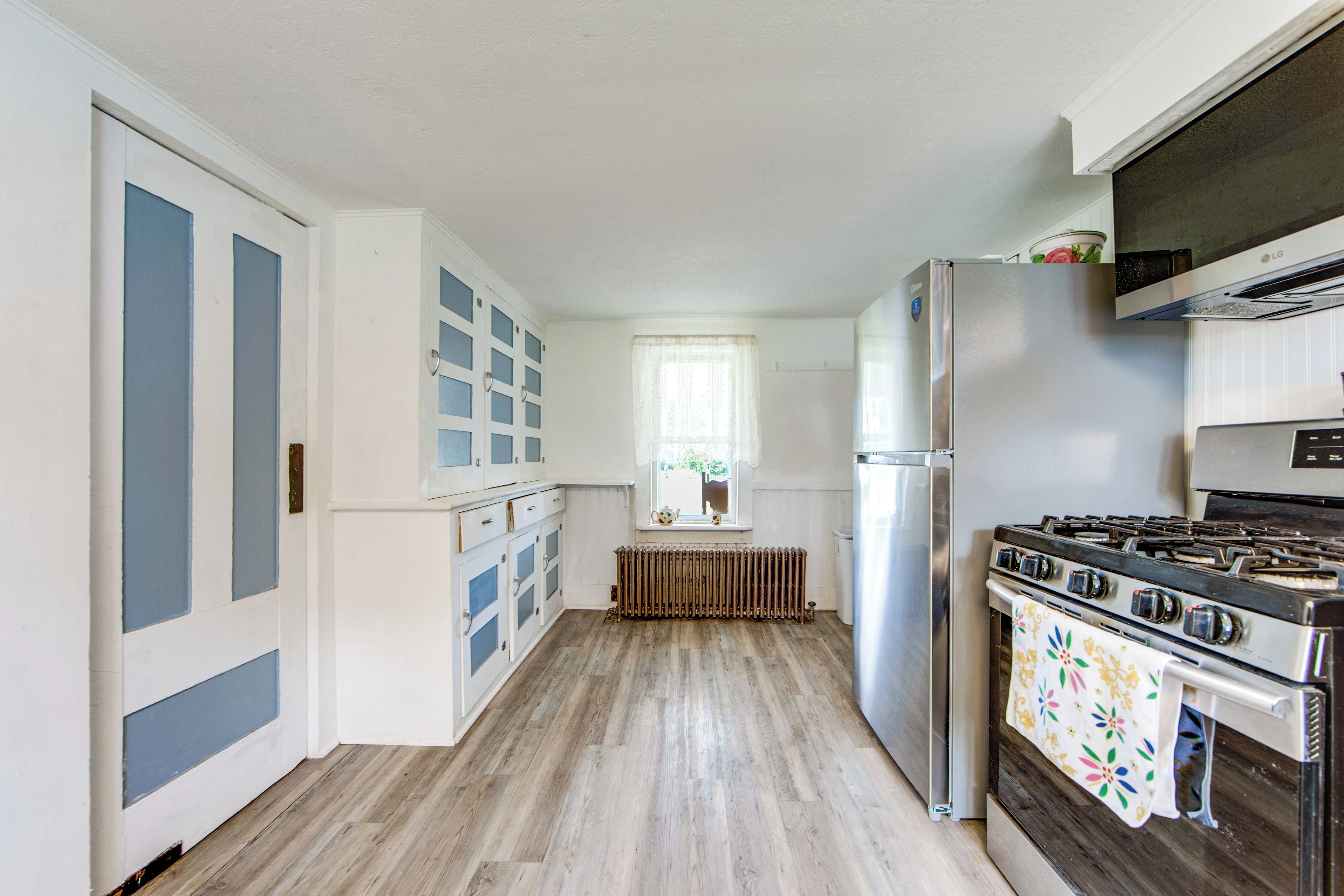 A kitchen with a stove, refrigerator, and cabinets.