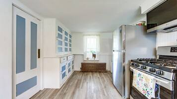 A kitchen with a stove, refrigerator, and cabinets.
