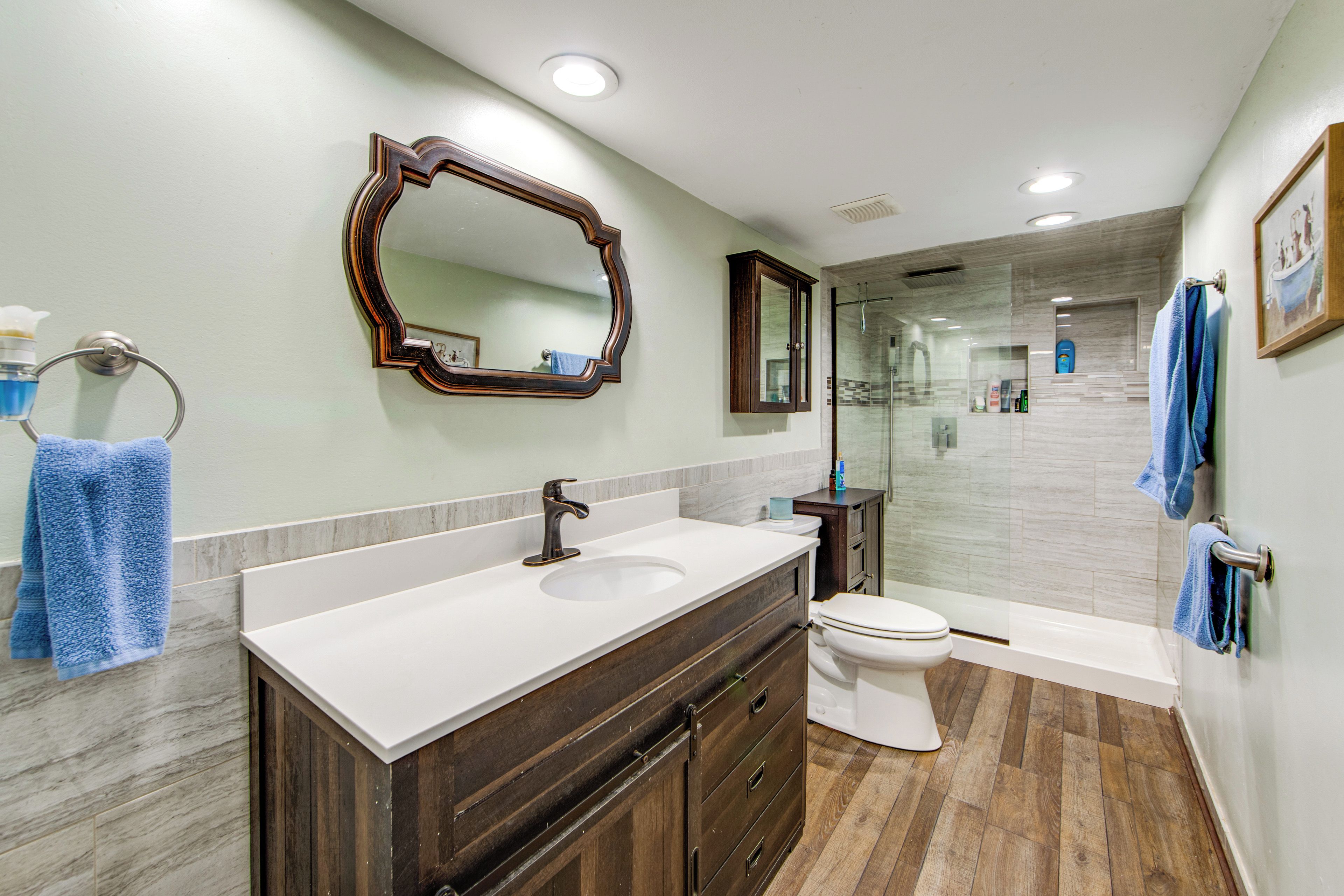 A modern bathroom with a vanity, a toilet, a shower, and a glass-enclosed shower area.