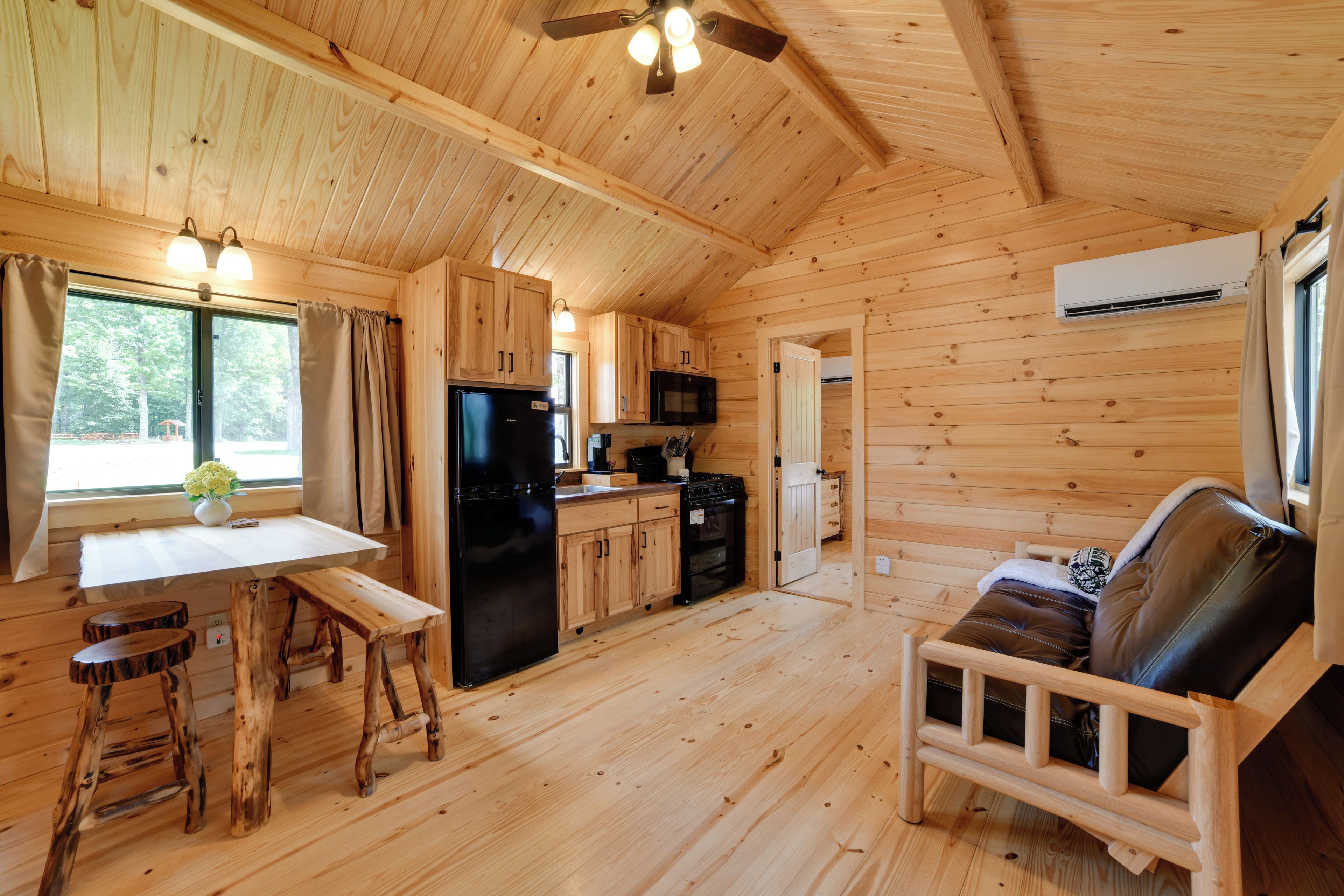 L’intérieur d’un chalet en bois comprend une cuisine, un coin repas et un espace salon.
