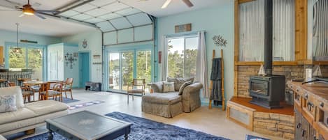 A spacious living room with a fireplace, a dining area, and a kitchen.