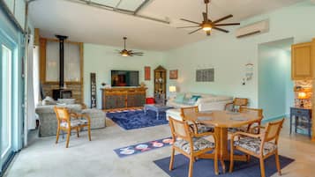 A spacious living area with a dining table, chairs, a sofa, and a fireplace.
