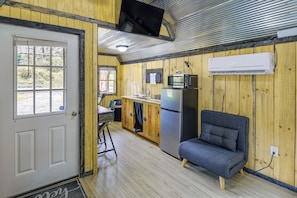 A compact kitchen with a refrigerator, microwave, and a sink.