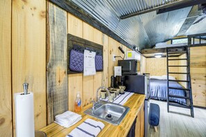 A compact room with a wooden interior, a sink, a coffee machine, and a bunk bed. - Near ATV Trails! Coal Heritage Cabin w/ Fire Pit (Roderfield)