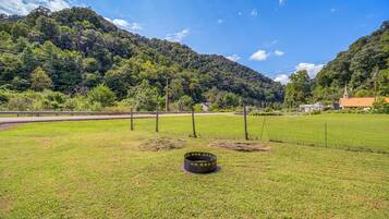A grassy field with a metal structure, a road, and a mountain in the background.