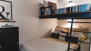 A bunk bed with pillows and a desk with a printer.