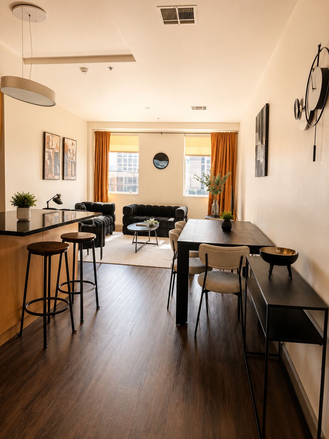 Un espace de vie moderne comprenant un coin repas, un canapé et un comptoir de cuisine.