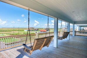 A covered outdoor area with wooden swings and a view of a distant landscape. - The Blue Crab - On Canal, boat slip w/lift, Bay access, outdoor bar (Gilchrist)