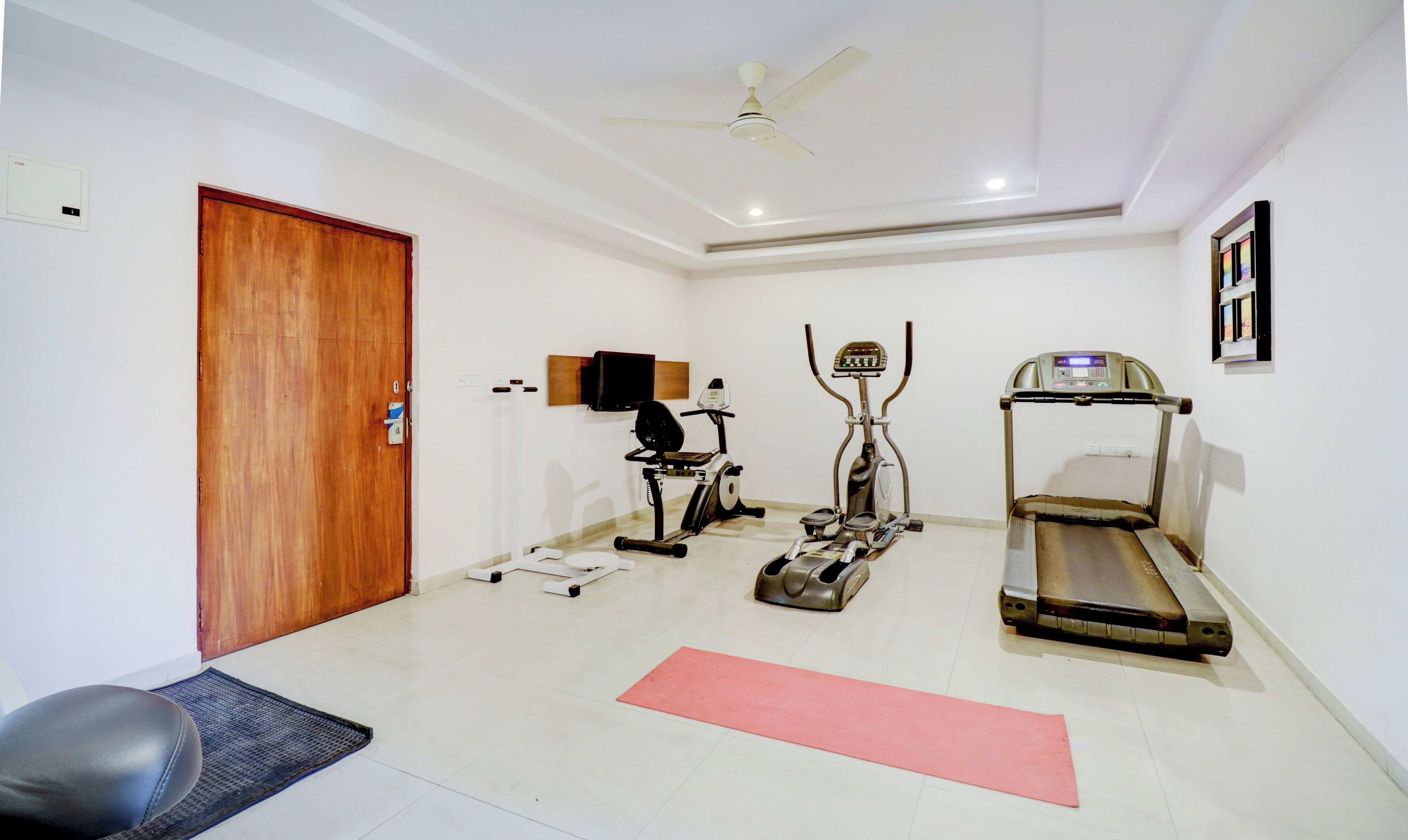 Una habitación con una caminadora, bicicleta estática y equipo de ejercicio.