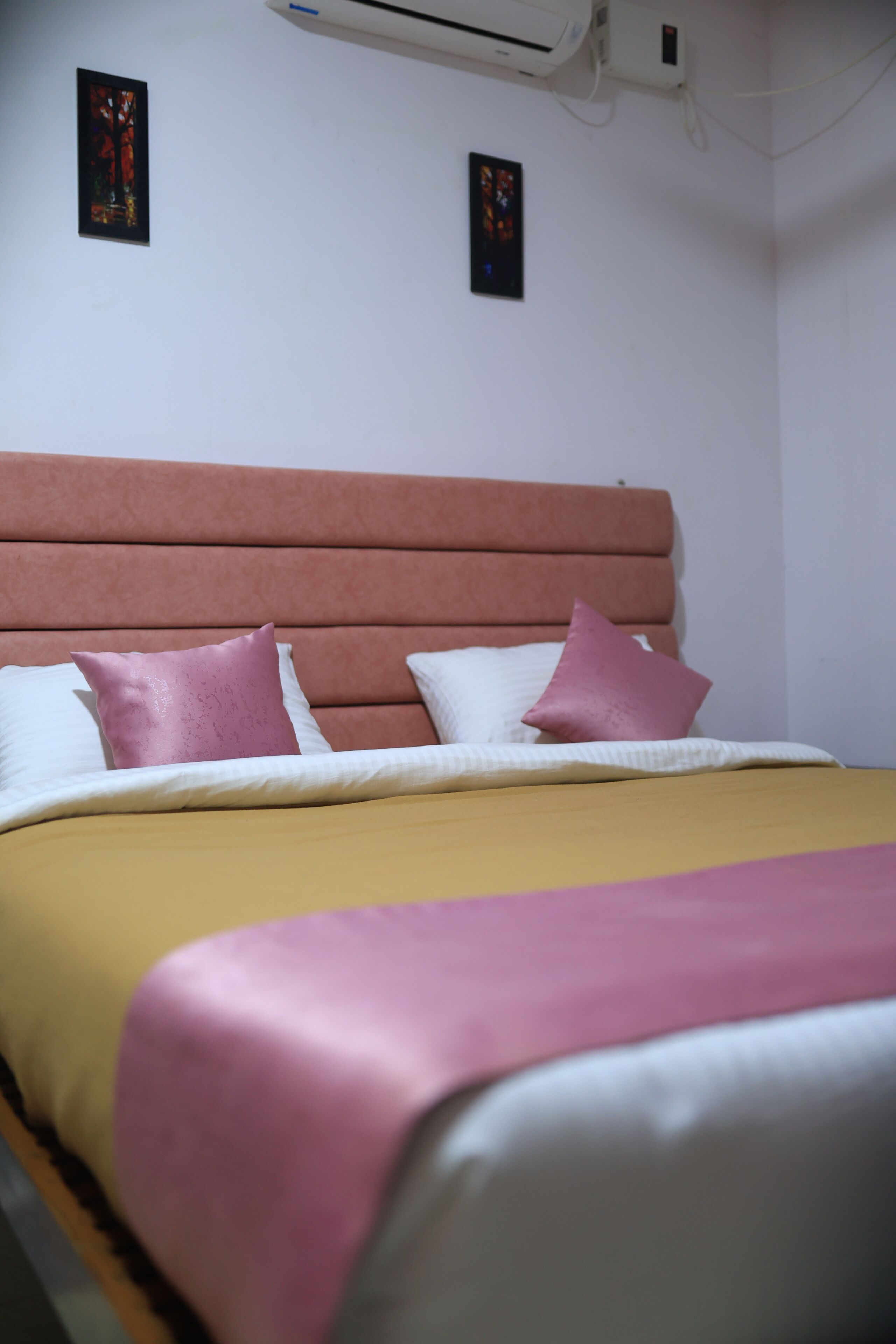 Een bed met hoofdbord, kussens en dekbed.