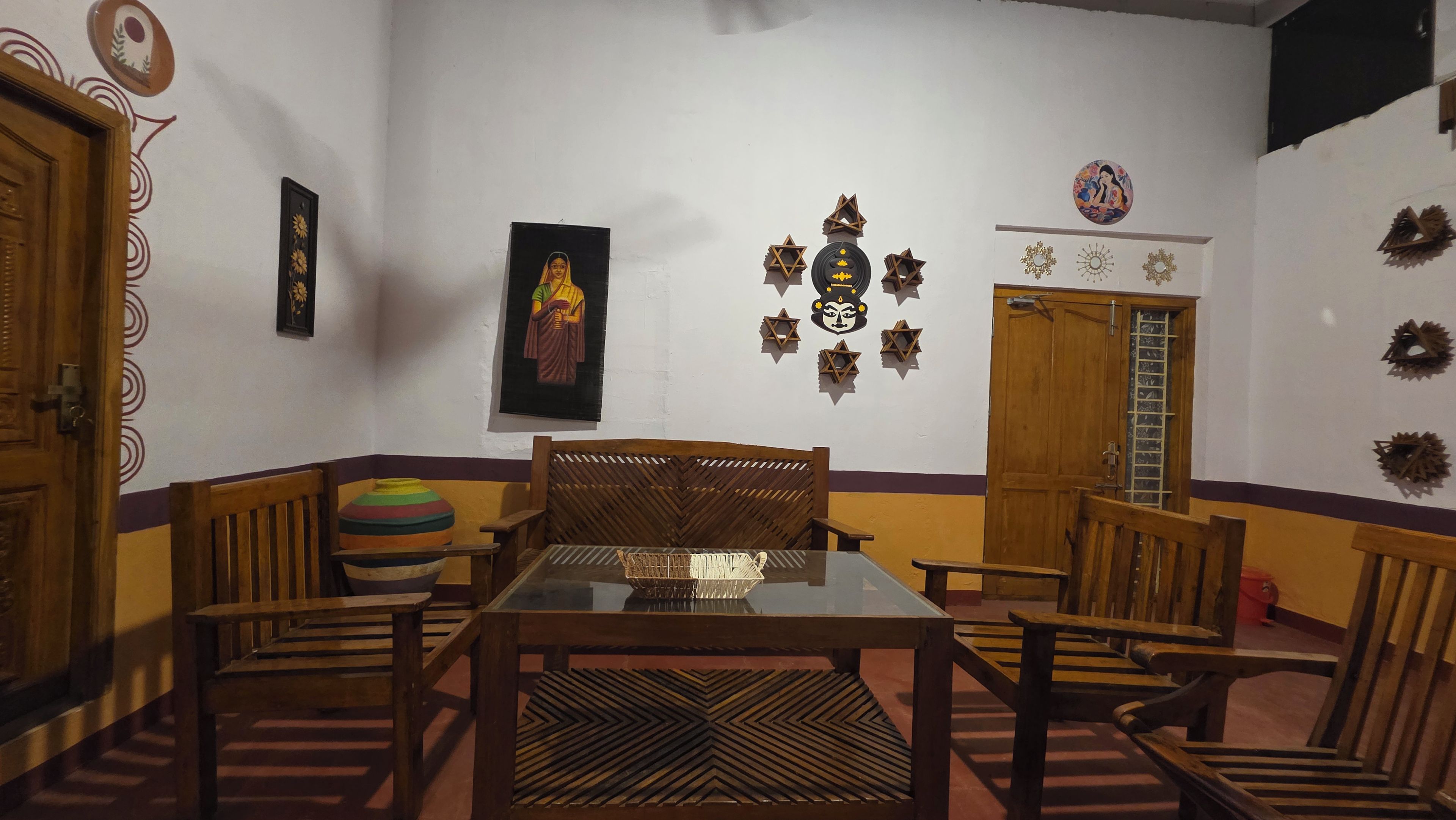 A dining area with a wooden table, chairs, and a patterned rug.