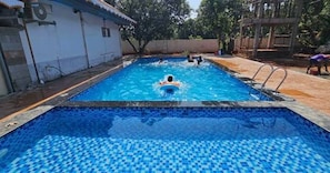 A swimming pool with a tiled floor and a ladder.