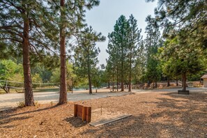 A park with tall pine trees, a wooden bench, and a dirt path. - Canopy Pines- Access to pool/lake (Arnold)
